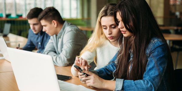 dos chicas estudian frente al ordenador